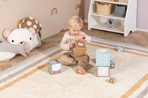 Vloerkleed in een ingerichte kinderkamer met zachte kleuren